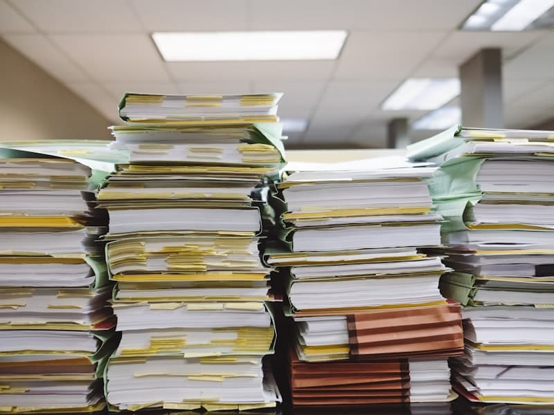 Stacked documents and file folders for MEES exemption registration