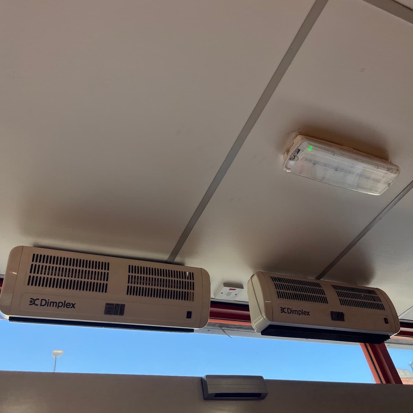 Two Dimplex air curtain units mounted above an entrance doorway