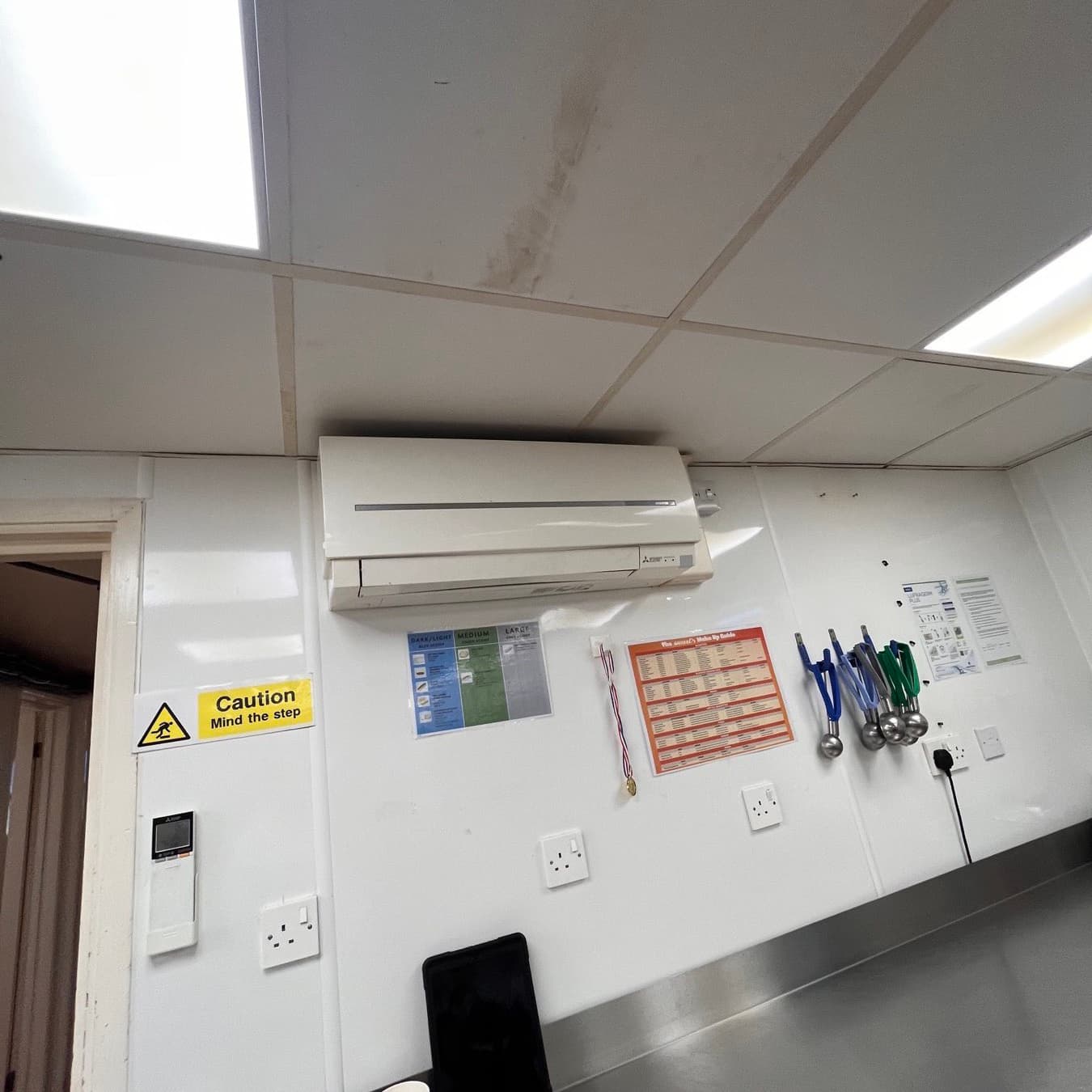 Mitsubishi wall-mounted split unit and controller in the back-of-house of a commercial kitchen